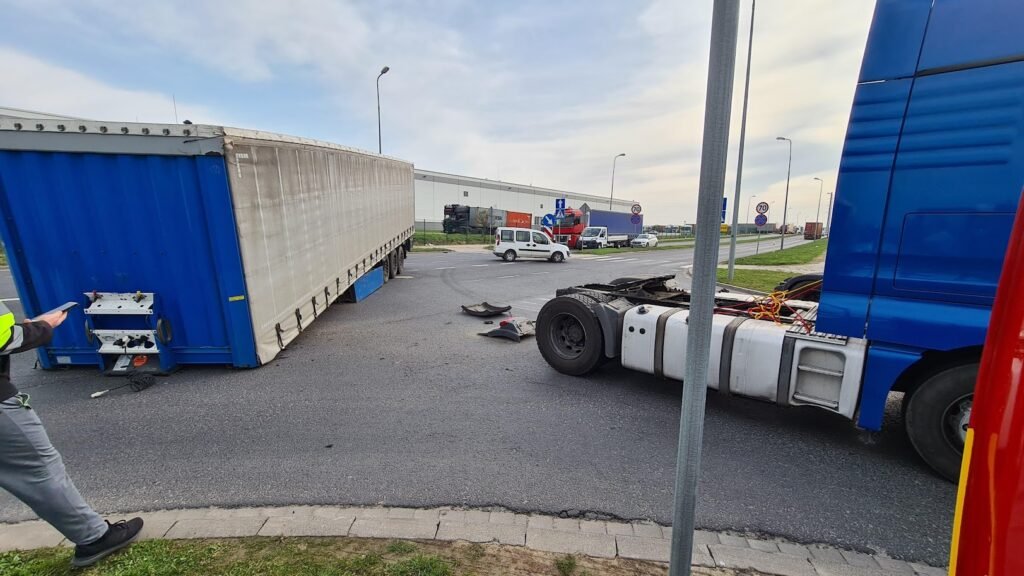 Laweta Środa Śląska transportująca uszkodzony pojazd na tle malowniczej okolicy.