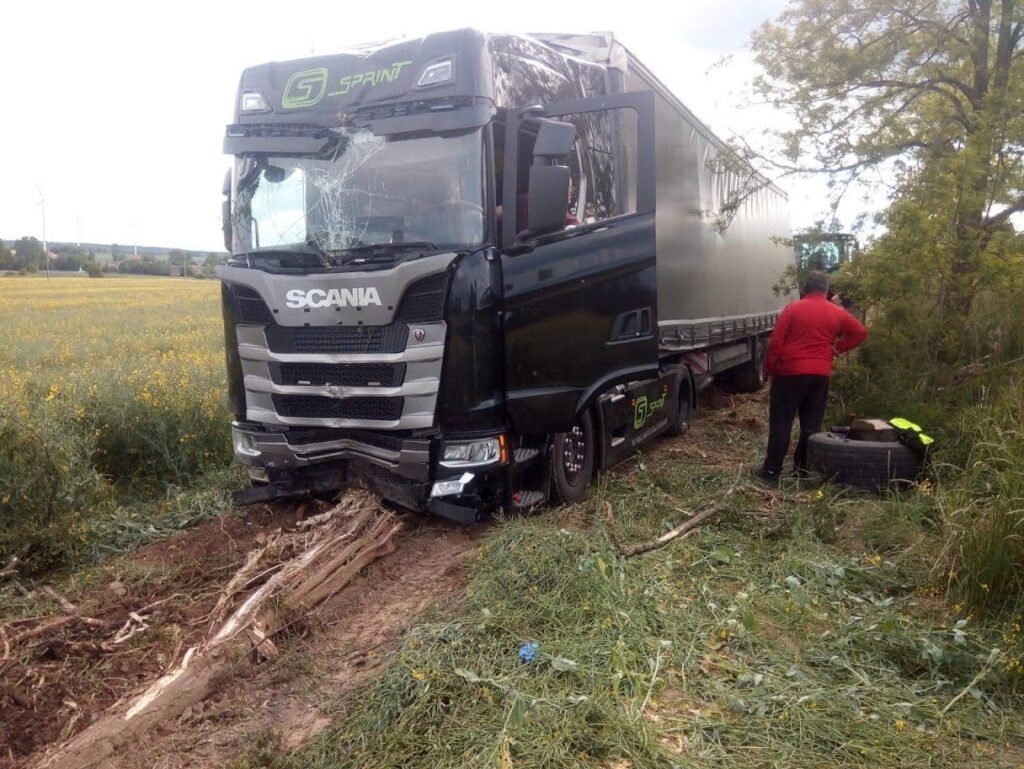 Laweta Środa Śląska holująca auto osobowe po kolizji na lokalnej drodze