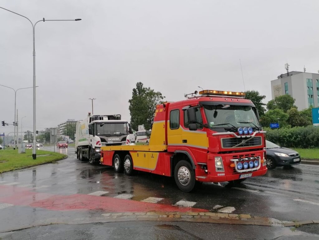 Laweta świadcząca usługę pomoc drogowa Środa Śląska podczas holowania samochodu osobowego na drodze lokalnej